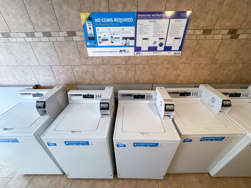 A row of washers and dryers in a laundry room.